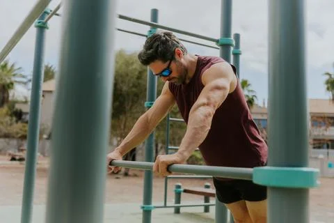 Portrait of a man during an intense workout at a calisthenics outdoor gym Stock Photos