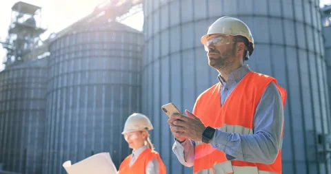 Portrait of man engineer in helmet texting on smartphone. Male Caucasian Stock Footage 138235914