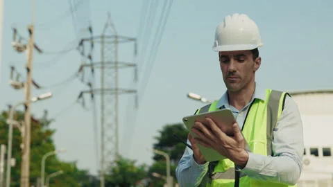 Portrait of man engineer looking away making notes on tablet standing at Stock Footage 312811499