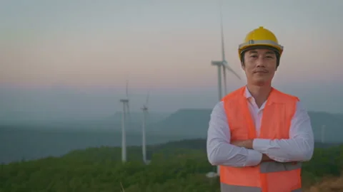 Portrait of a man engineer is smiling in a field  wearing a protective helmet Vídeo Stock 149049269