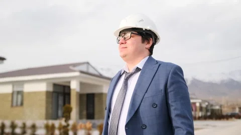 Portrait of man engineer in white hard hat looking seriously progress of work Stock Footage 268383028