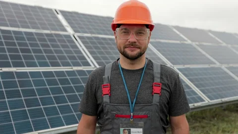 Portrait of man engineer in working clothes standing on solar panel field. Clean Stock Footage 156806643