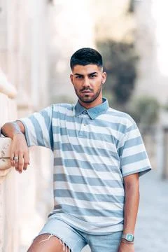 Portrait of a man facing the camera while leaning on the wall Stock Photos