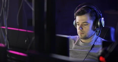 Portrait of man gamer playing computer game in headphones looking at screen. Stock Footage 122482048