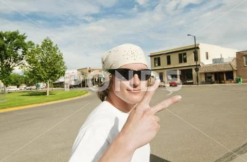 Portrait of man gesturing while standing against buildings in city Stock Photos