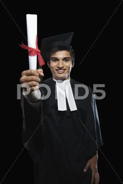 Portrait of a man in a graduation gown holding a diploma Stock Photos