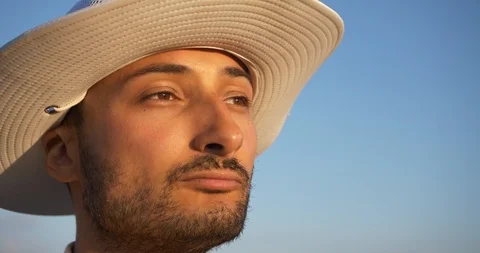 Portrait of a man with a hat and a beard in the rays of the sunset Stock Footage 92005777