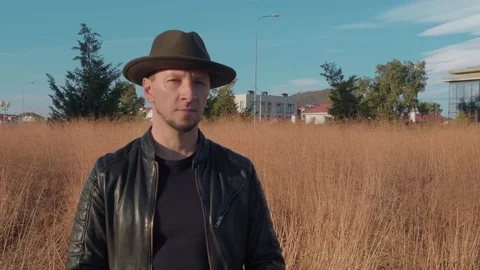 Portrait of a man in a hat and leather jacket stands in the Park with a retro Stockbeeldmateriaal 121807261