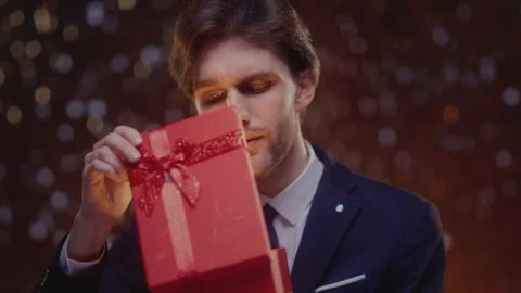 Portrait: man holding box bow, open surprise gift. Male in suit opens the Stock Footage 324002850