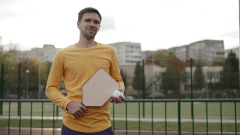Portrait of man holding pickleball racket and ball at stadium. Stock Footage 254757148
