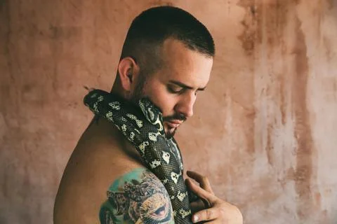 Portrait of man hugging a snake 写真素材
