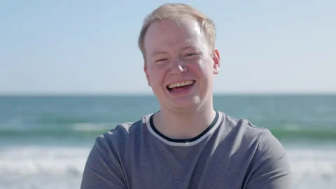Portrait of a man laughing while enjoying summer vacation at seaside Stock Footage 197580103