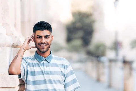 Portrait of a man leaning in a wall while smiling to camera outdoors Stock Photos
