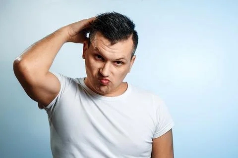 Portrait of a man on a light background, expresses uncertainty, ignorance. Th Stock Photos