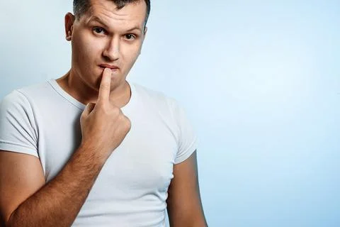 Portrait of a man on a light background, expresses uncertainty, ignorance. Th Stock Photos
