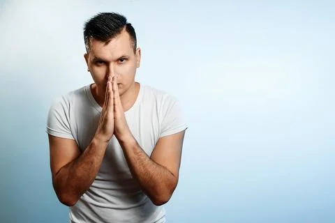 Portrait of a man on a light background, folded his hands in front of him in  Stock Photos