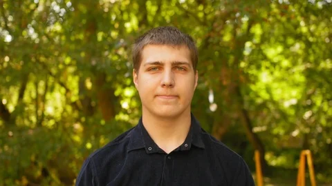 Portrait of man looking into the camera and smiling outdoors. Close up shot. Stock Footage 118546563