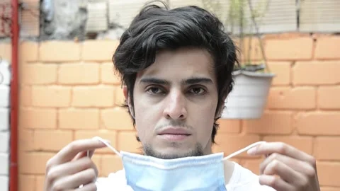 Portrait of a man looking at camera smiling and donning a face mask Stock Footage 143355649