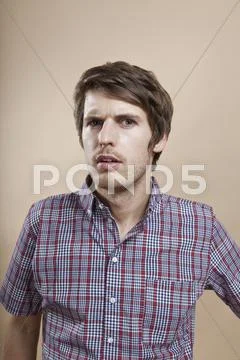 Portrait of a man looking confused, studio shot Stock Photos