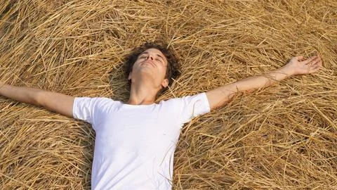 Portrait of a man lying in a haystack. Falling into a stack 写真素材
