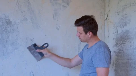 Portrait of man making renovation removing wallpapers from wall at home. Stock Footage 124948333