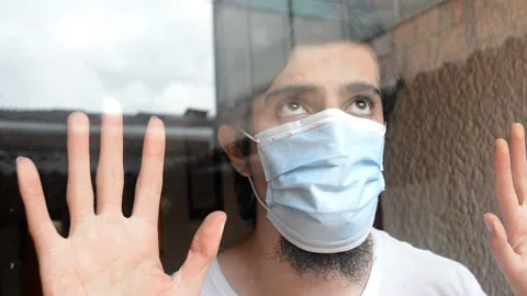 Portrait of a man with mask looking through the window, sky n buildings reflexed Stock Footage 143355651