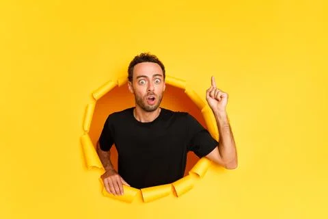 Portrait of a man model points index finger up to copy space shows some Stock Photos