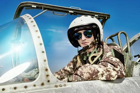 Portrait of a man pilot wearing helmet in cockpit of fighter jet. Military ai Stock Photos