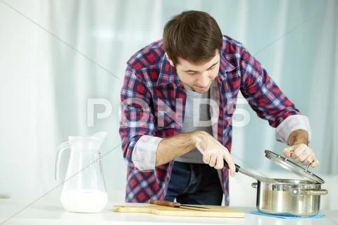 Portrait of man preparing food at kitchen Stock Photos