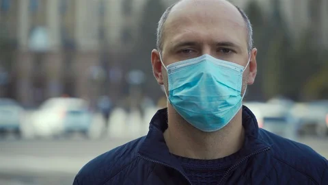 Portrait man in protective face mask look at camera during pandemic or epidemic Vidéo 128740379