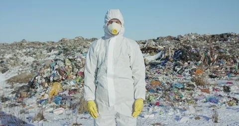 Portrait of man in protective form look at camera on plastic landfill background Video stock 125363524