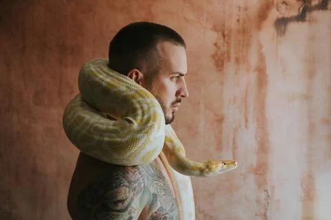 Portrait of man with python circling his neck Stock Photos