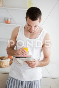 Portrait of a man reading the news while drinking orange juice Stock Photos