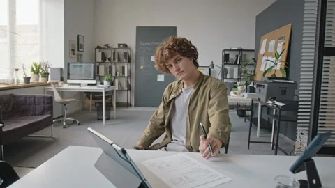 Portrait of Man Reviewing Documents at Modern Office Desk Stock Footage 345250176