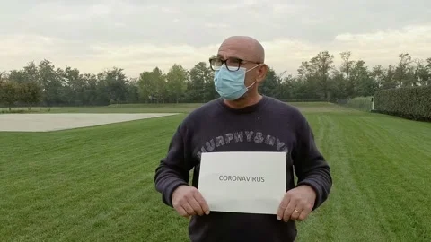 Portrait of Man with Sign Coronavirus While Wears a Medical Mask During Covid-19 Stock Footage 141606819