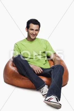 Portrait of a man sitting on a bean bag and smiling Stock Photos
