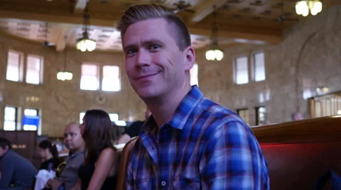 Portrait of man sitting on bench in train station 스톡 동영상 67353937