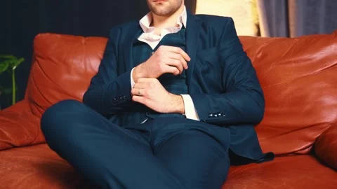 Portrait man sitting on red leather chair sofa, room loft style face cropped Stock Footage 311827788