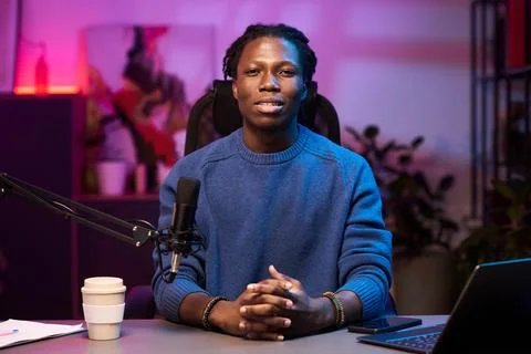 Portrait of Man Sitting in Studio with Microphone and Laptop Foto stock