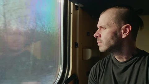 Portrait of a man sitting in a train car and looking out the window. Stock Footage 168834637