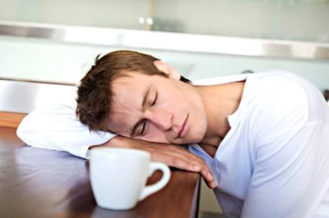 Portrait of a man sleeping on table in kitchen, indoors Stock Photos