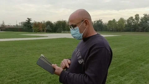 Portrait of Man with Smartphone at Garden While Wears a Medical Mask Stock Footage 141606458
