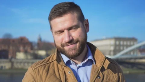Portrait of man smiling at camera on the background of the river, close shot 库存影片 72709825