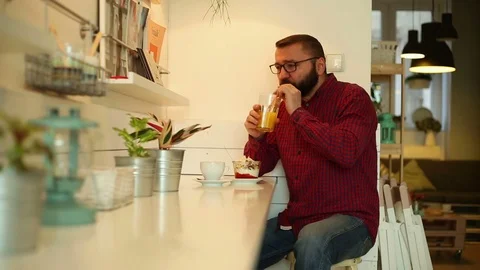 Portrait of man smiling to the camera in the cafe, and drinking orange juice Stock Footage 70859443