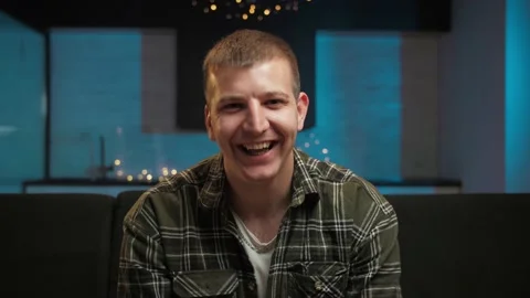 Portrait of Man smiling sitting on the couch in home interior.Guy face reaction Stock Footage 225653192