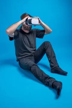 Portrait of a man standing down arranging his VR device Stock Photos