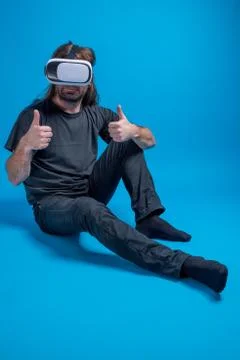 Portrait of a man standing down displaying thumbs up and enjoying a modern VR Stock Photos