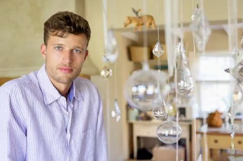 Portrait of a man standing by the wind chime at house Stock Photos