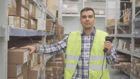 Portrait man store worker using bar code scanner scanning labels on boxes Stock Photos