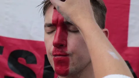 Portrait of man supporting his team with the flag of England painted on his face Vídeo Stock 149400802